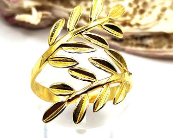 Puede incluir: Un anillo de oro con un diseño de hojas. El anillo está hecho de una sola pieza de metal que se ha dado forma de una serie de hojas.