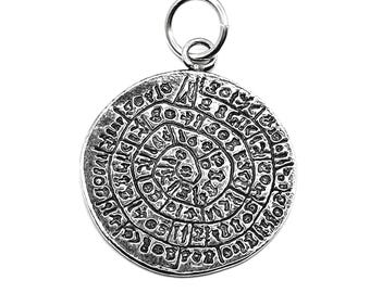 May include: Silver pendant with a circular design featuring a spiral of letters and numbers. The pendant has a loop at the top for attaching to a chain.