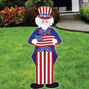 May include: A patriotic yard decoration featuring Uncle Sam holding an American flag. The cutout has a blue coat, red and white striped pants, and a tall hat with stars. The lawn ornament is designed for outdoor display.