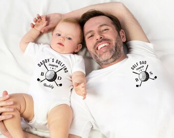May include: A white onesie with the text "Daddy's Golfing Champion Buddy" and a golf ball graphic. A white t-shirt with the text "Golf Dad Champion Boss" and a golf ball graphic.