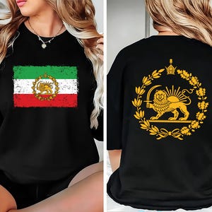 May include: Black t-shirt featuring the Iranian flag on the front, with green, white, and red stripes and a central emblem. The back of the shirt displays a gold emblem of a lion holding a sword within a wreath.