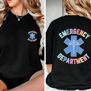 May include: Black sweatshirt with a rainbow coloured "EMERGENCY DEPARTMENT" graphic on the back and a smaller version of the graphic on the front left chest.