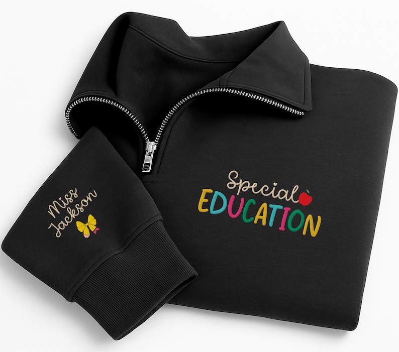 May include: Black sweatshirt with a quarter-zip collar. The sleeve cuff features the embroidered text "Miss Jackson" and a yellow butterfly. The front of the sweatshirt displays the words "Special Education" in colorful embroidery, with a red apple graphic.