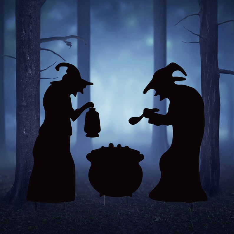 May include: Two black silhouette figures of witches standing in a foggy forest setting. The witches are wearing pointed hats and long robes. One witch is holding a lantern and the other is holding a ladle. A black cauldron sits between them.