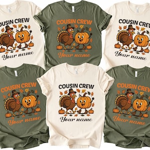 May include: A collection of six t-shirts in various colors, each featuring a Thanksgiving-themed graphic. The design includes a cartoon turkey and pumpkin with the text "COUSIN CREW" and space for a personalized name. The shirts are in cream, olive green, and dark green.