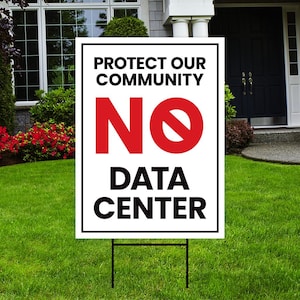 May include: A rectangular white yard sign with a black border featuring the text PROTECT OUR COMMUNITY in black, a large red NO symbol, and the text DATA CENTER in black. The sign is supported by a thin black metal wire frame stake.