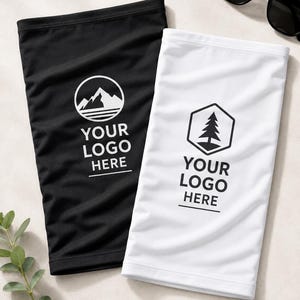May include: Two neck gaiters, one black and one white, are displayed. The black gaiter features a mountain range logo and the text "YOUR LOGO HERE." The white gaiter has a tree logo and the same text. Sunglasses are visible in the background.