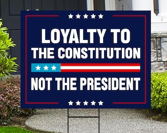 May include: A blue and red yard sign with white text that reads "Loyalty to the Constitution Not the President". The sign has a red, white, and blue American flag design.