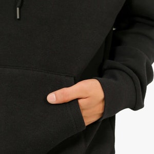May include: Black hooded sweatshirt with a kangaroo pocket. The sweatshirt is made of a soft, comfortable fabric.