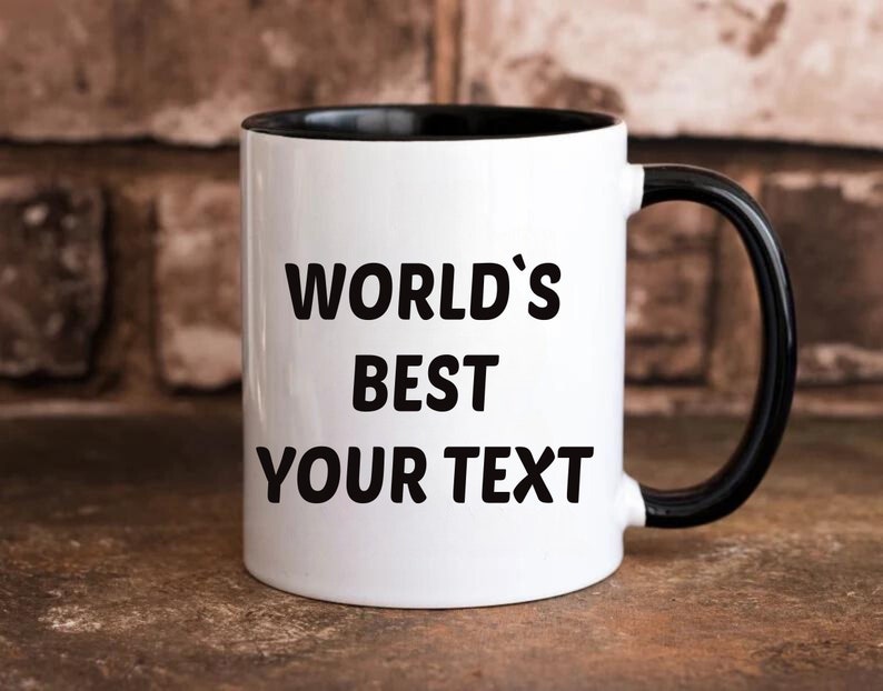 May include: White ceramic mug with a black rim and handle. The mug has black text that reads "WORLD'S BEST YOUR TEXT".
