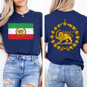 May include: Navy blue t-shirt featuring the Iranian flag on the front and a golden lion emblem on the back. The front design shows a distressed flag with green, white, and red stripes. The back displays a golden lion with a sword.