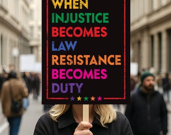 Puede incluir: Un cartel negro con el texto "WHEN INJUSTICE BECOMES LAW RESISTANCE BECOMES DUTY" en letras coloridas. El cartel lo sostiene una persona entre la multitud. El texto está enmarcado por un borde rojo y estrellas.