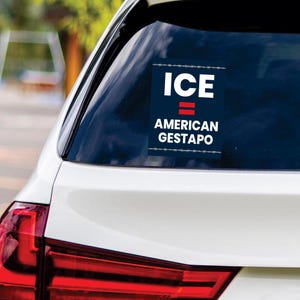 May include: A rectangular sticker on a car window with the words "ICE = AMERICAN GESTAPO" in white text on a navy blue background. The sticker has a barbed wire design at the top and bottom.