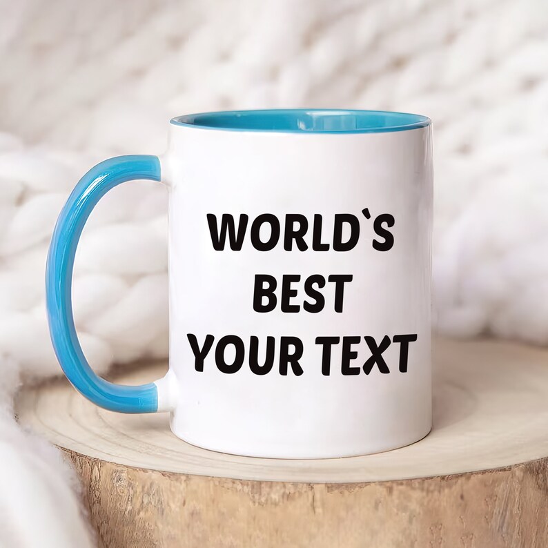 May include: White ceramic mug with a blue rim and handle. The mug has the text "WORLD'S BEST YOUR TEXT" printed on it.