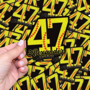 May include: A yellow and black sticker featuring the number 47 with red baseball stitching. The name "Alexander" is written in cursive below the number. The sticker is held by a hand, with other similar stickers in the background.