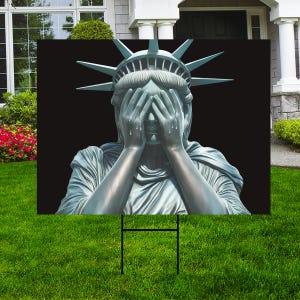 May include: A statue of the Statue of Liberty with her hands over her eyes, as if she is crying. The statue is in front of a black background.