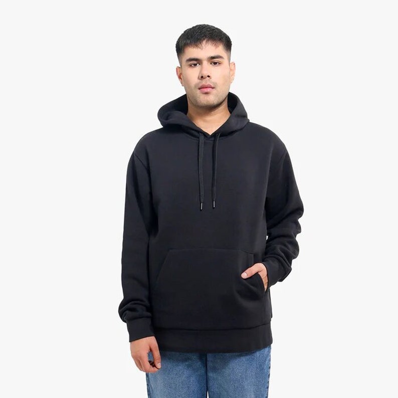 May include: A black hooded sweatshirt with a pouch pocket. The sweatshirt has a drawstring hood.