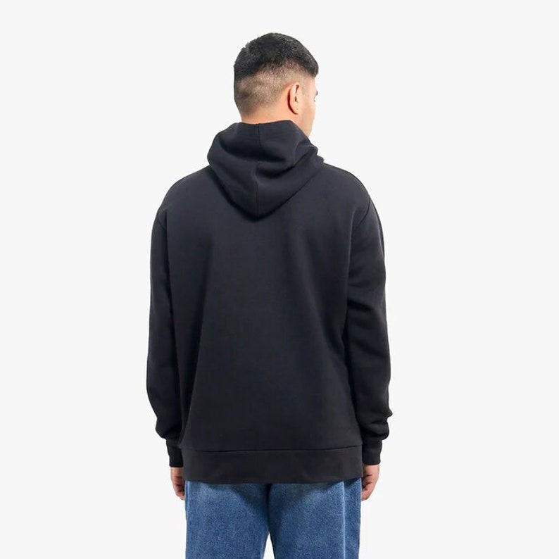 May include: A black hooded sweatshirt with a drawstring hood. The sweatshirt has long sleeves and a kangaroo pocket.