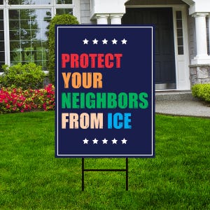May include: A dark blue yard sign with the text "PROTECT YOUR NEIGHBORS FROM ICE" in red, orange, green, and light blue. The sign has white stars at the top and bottom and is displayed on a black metal stand in a grassy yard.