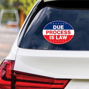 May include: A white car with a red, white, and blue oval sticker on the back window. The sticker says "Due Process Is Law" with stars around the edge.
