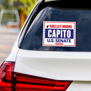May include: A rectangular sticker on a car window displays the text "Shelley Moore Capito U.S. Senate 2026" in white and blue. The sticker has a red border and a state silhouette.