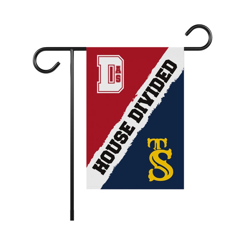 K&ouml;nnte beinhalten: Eine rot-blaue Gartenflagge mit dem Text "House Divided" in Wei&szlig;. Die Flagge zeigt au&szlig;erdem die Buchstaben "D.A.S." in Wei&szlig; auf rotem Hintergrund und die Buchstaben "T.S." in Gelb auf blauem Hintergrund.
