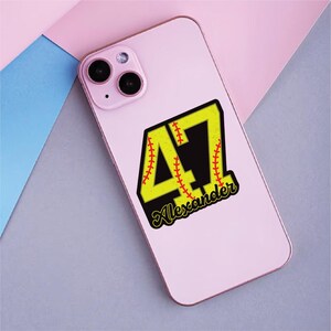 May include: A pink smartphone case with a baseball-themed design. The design features the number 47 in yellow with red stitching, a black background, and the name "Alexander" in a script font.