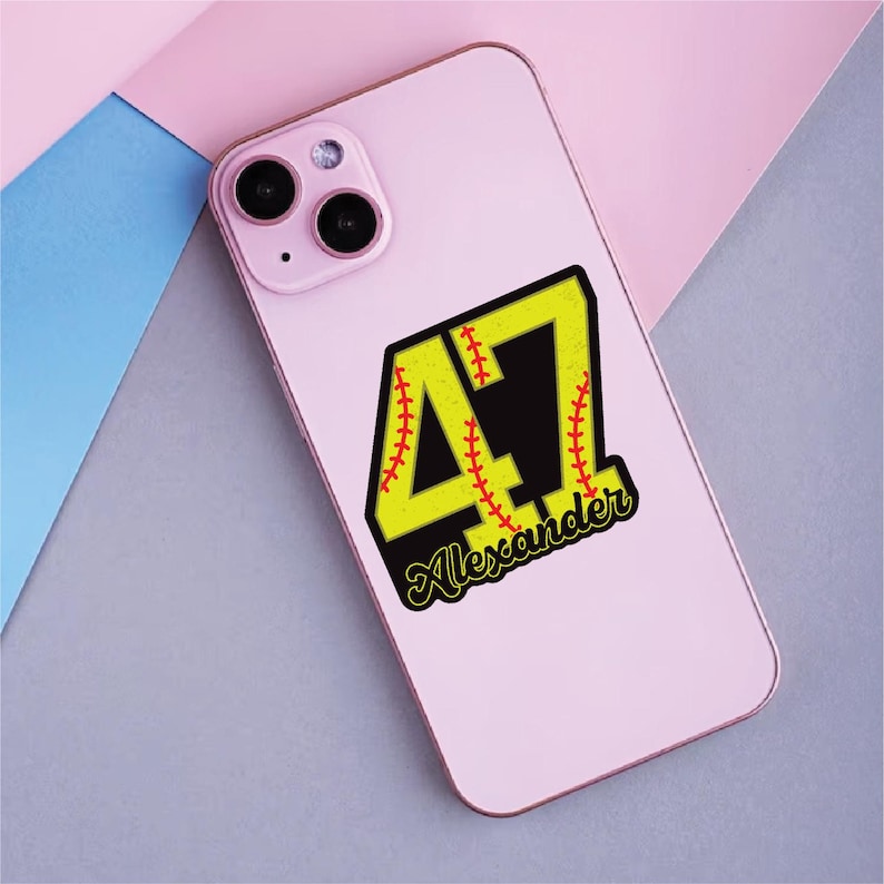 May include: A pink smartphone case with a baseball-themed design. The design features the number 47 in yellow with red stitching, a black background, and the name "Alexander" in a script font.