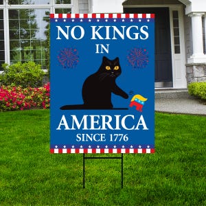 May include: A blue yard sign with the text "NO KINGS IN AMERICA SINCE 1776". The sign features a black cat with yellow eyes and a red, white, and blue graphic. The top and bottom borders have a red and white star pattern.
