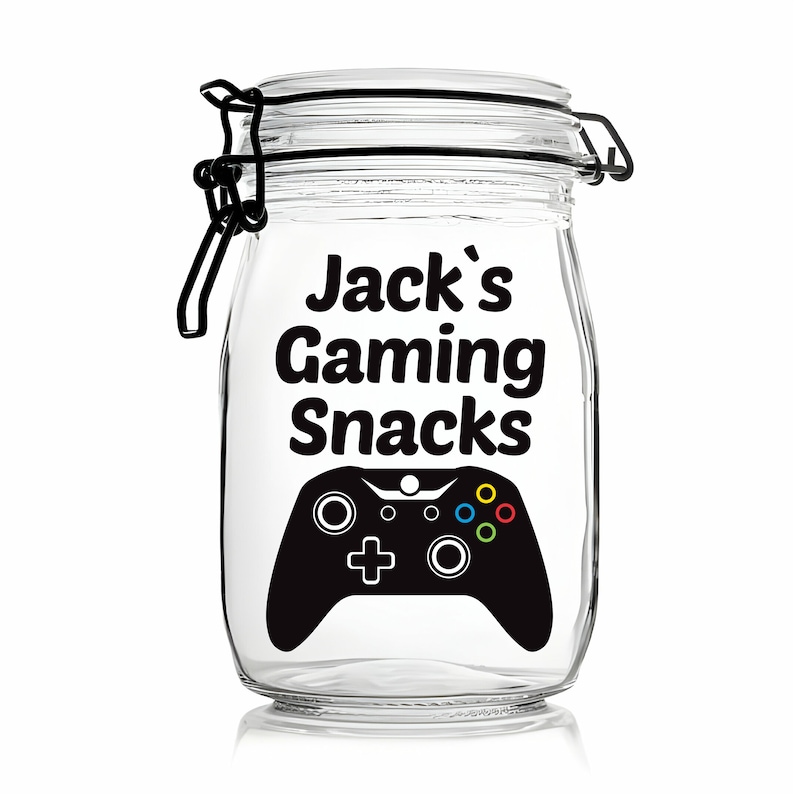 Peut inclure: Un pot en verre transparent avec un couvercle noir et une fermeture &agrave; clip noire. Le pot est d&eacute;cor&eacute; d'un autocollant noir et blanc avec le texte "Jack's Gaming Snacks" et un graphisme de manette de jeu vid&eacute;o noire.