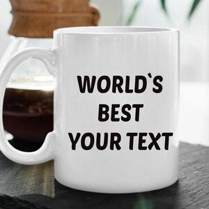May include: White ceramic mug with black text that reads "WORLD'S BEST YOUR TEXT".