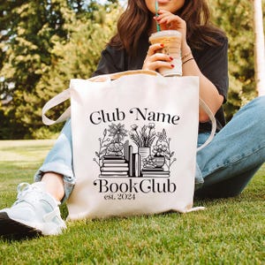 Puede incluir: Una bolsa de tela blanca con texto negro y un gr&aacute;fico de libros y plantas. El texto dice "Club Name Book Club est. 2024".