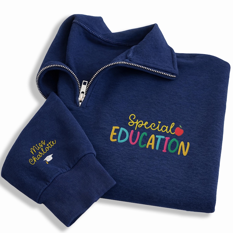 May include: Navy blue quarter-zip sweatshirt with the words "Special EDUCATION" in colorful embroidery. The left sleeve cuff features the name "Miss Charlotte" and a graduation cap. The sweatshirt has a silver zipper.