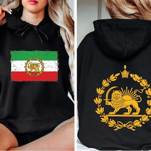 May include: Black hoodie featuring the Iranian flag on the front, with green, white, and red stripes and a lion emblem. The back displays a gold lion emblem within a wreath. The hoodie has a drawstring hood.