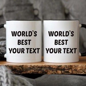 May include: Two white ceramic mugs with black handles and black rims. The mugs have the text "World's Best" and "Your Text" printed on them.