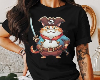 May include: Black t-shirt with a cartoon illustration of a cat dressed as a pirate. The cat is wearing a black hat with a skull and crossbones, a blue and red jacket, and a brown belt with a sword. The cat is holding a sword in its right paw.