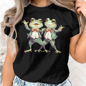 May include: Black t-shirt with a graphic of two green frogs wearing bow ties and suits, dancing.