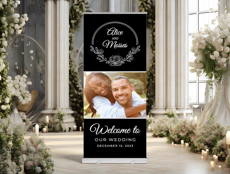 May include: Black and white wedding welcome sign with a floral wreath and the names Alice and Moises. The sign also includes a photo of the couple and the text "Welcome to our wedding, December 15, 2023".