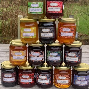 May include: A pyramid display of 12 glass jars of jam and marmalade. The jars are labelled with the name "The Chiltern Pantry" and the type of jam or marmalade inside. Some of the flavours include: Seedless Raspberry Jam, Seedless Blackberry Jam, Ginger Marmalade, Mixed Berry Jam with Gin, and Seville Orange Marmalade.