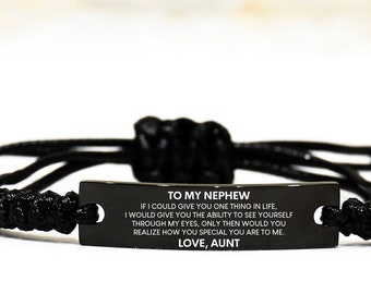 May include: A black cord bracelet featuring a rectangular metal plate engraved with the text: TO MY NEPHEW IF I COULD GIVE YOU ONE THING IN LIFE, I WOULD GIVE YOU THE ABILITY TO SEE YOURSELF THROUGH MY EYES, ONLY THEN WOULD YOU REALIZE HOW YOU SPECIAL YOU ARE TO ME. LOVE, AUNT.