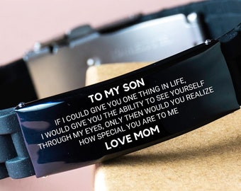 Op de afbeelding: Zwart siliconen armband met een roestvrijstalen sluiting. De zwarte plaat heeft de tekst "TO MY SON" en een boodschap van "LOVE MOM". De armband is een attent cadeau.