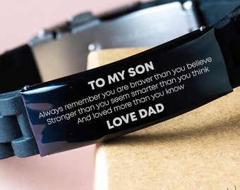 Op de afbeelding: Zwarte siliconen armband met een roestvrijstalen sluiting. De armband heeft de tekst "TO MY SON" en een boodschap van "LOVE DAD". De armband is een attent cadeau.