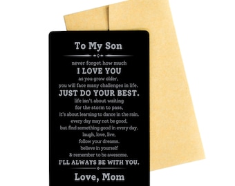 Op de afbeelding: Zwarte kaart met witte tekst die "To My Son" zegt en een boodschap van aanmoediging en liefde van een moeder aan haar zoon bevat. De kaart ligt op een bruine envelop.