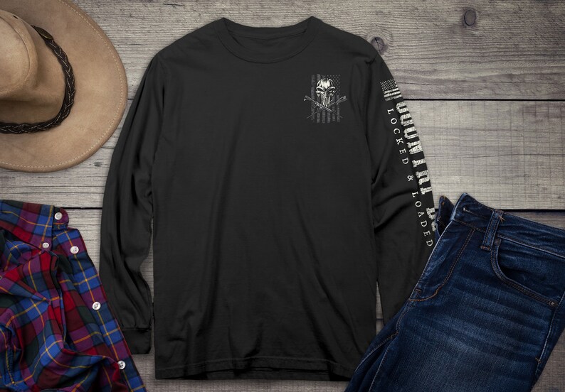Op de afbeelding: Zwart langarm T-shirt met een witte schedel en gekruiste botten afbeelding op de linker borst en de tekst "LOCKED & LOADED" op de rechter mouw.
