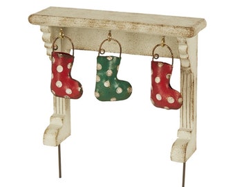 May include: White wooden mantel with three hanging stockings. The stockings are red and white polka dot, green and white polka dot, and red and white polka dot. The mantel has a distressed white finish.