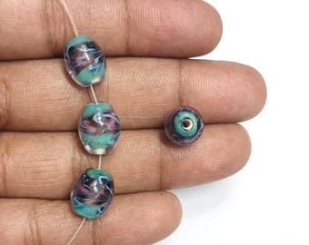 Cantidad: 20 cuentas de vidrio de Murano ovaladas de 14 x 8 mm en color púrpura y azul