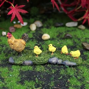 May include: A brown and white hen with a red comb stands on a mossy rock with four yellow chicks following behind.