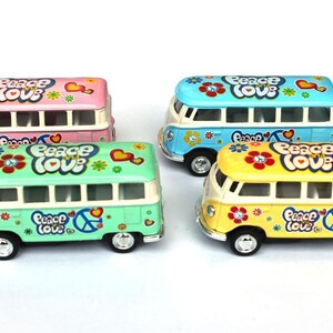 May include: Four miniature metal toy vans in pink, light blue, mint green, and yellow. Each van features white trim, black wheels, and colorful floral graphics with the text "peace love" and a peace sign symbol printed on the sides and roof.