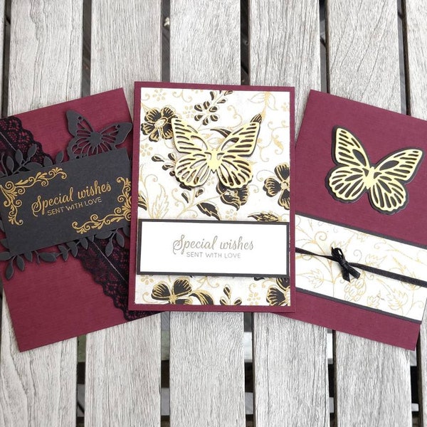 Handgemachte Grußkarten zum Geburtstag oder jeden Anlass. Burgunderfarbene Basiskarten mit zarten Goldmusterpapieren, verziert mit Schmetterlingen