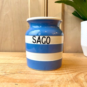 May include: A blue and white striped ceramic jar with the word "SAGO" printed in black on the front.